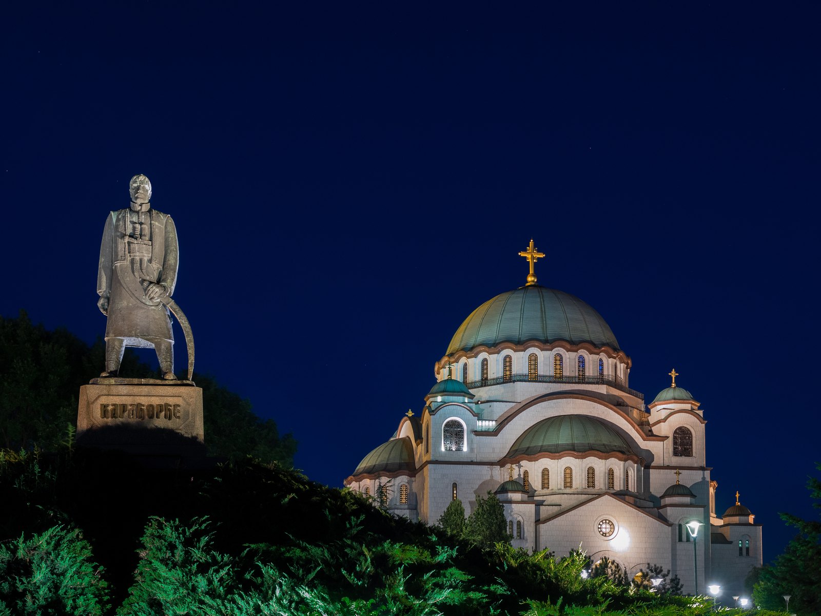 The Church of Saint Sava on Vračar, Belgrade, floodlit at night, with the Karađorđe monument at left
